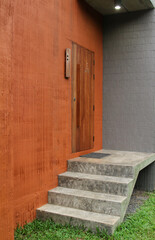 Wooden door on orange concrete wall in hotel resort.
