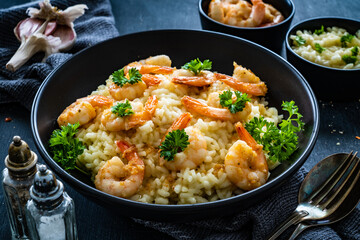 Risotto with prawns, chili and parsley on wooden table

