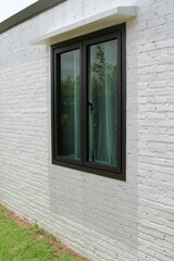 A black window on white brick wall.