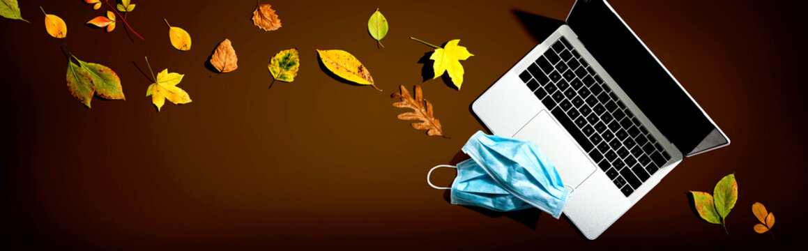 Laptop computer with masks in autumn - overhead view