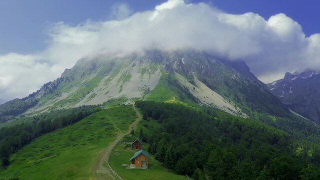 Small houses at mountain with contryside roads in Komovi, Montenegro. Aerial drone view.