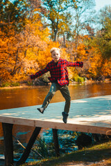 A boy on a walk in an autumn park  the lake