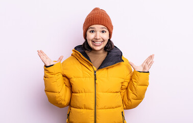 pretty young woman feeling happy and astonished at something unbelievable. cold weather concept