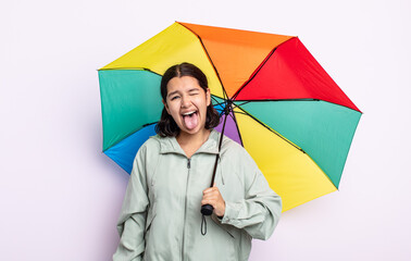 pretty young woman with cheerful and rebellious attitude, joking and sticking tongue out. rain and...