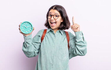 pretty young woman feeling like a happy and excited genius after realizing an idea. alarm clock...