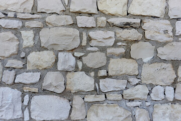 Texture of a gray stone wall. Old Facade Exterior Construction Industry Concept Wallpaper. Handmade stone masonry.