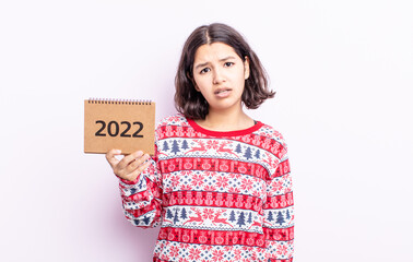pretty young woman feeling puzzled and confused. 2022 calendar concept