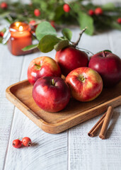 Autumn or winter background with apples, cinnamon, candle and hawthorn