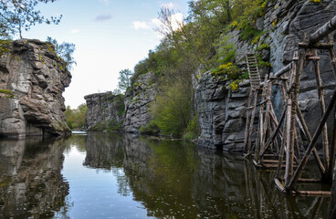 Fototapeta na wymiar Buky Canyon, calm flow of Hirskyi Tikych river near high granite rocks, Cherkasy Region. Sights and nature of Ukraine.