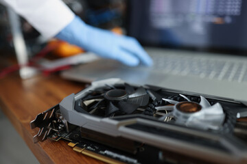 Video card lying on table near open laptop closeup