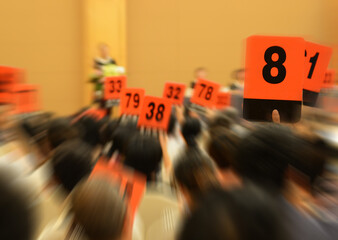 People holding auction paddle to buy from auction.