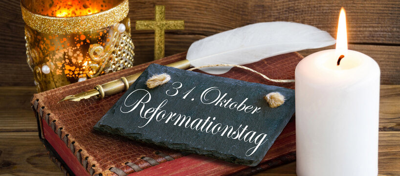 Reformationstag mit Bibel, Kreuz und Kerze
