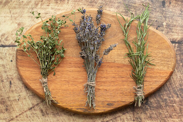 Bunches of dried lavender, thyme and rosemary on a wooden background. Traditional Medicine Concept