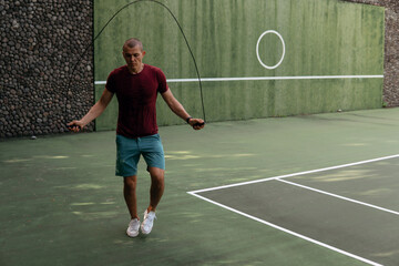 man jumping rope on the tennis court