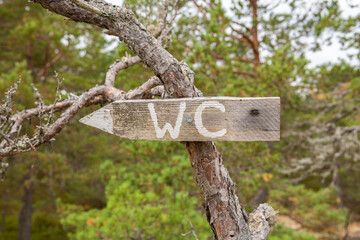 Wooden WC sign in the forest, Raseborg, Finland