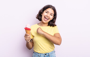 pretty young woman feeling happy and facing a challenge or celebrating. ice cream concept