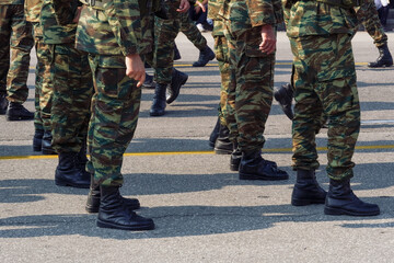 Greek Army soldiers in combat uniform during parade. Silhouette of Hellenic Armed forces males wearing black boots and battle clothing in a camouflage pattern.
