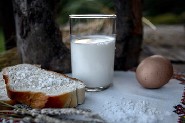 A glass of milk close-up, boiled egg and white bread with coarse salt. A simple breakfast, a hearty...