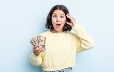 pretty young woman looking happy, astonished and surprised. dollar banknotes concept