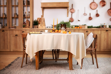 Interior design scandinavian kitchen with round table and chairs. Stylish dining room in rustic style. Cozy Wooden kitchen decorated Christmas or new year. On table fir branche in vase, Xmas cookies