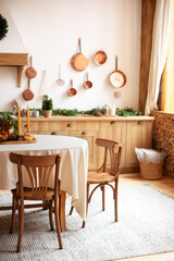 Interior design scandinavian kitchen with round table and chairs. Stylish dining room in rustic style. Cozy Wooden kitchen decorated Christmas or new year. On table fir branche in vase, Xmas cookies	