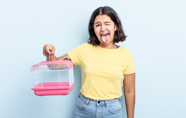 pretty young woman with cheerful and rebellious attitude, joking and sticking tongue out. pet cage...