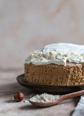 Homemade sponge cake or biscuit with nuts and spices decorated with butter cream or cream cheese icing.