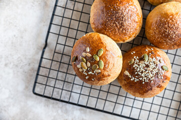 Fresh homemade pumpkin buns with brown sugar or seeds, light concrete background. Autumn bakery.