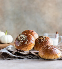 Sweet pumpkin buns with cinnamon and anise, light concrete background.
