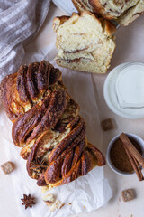 Cinnamon and brown sugar babka or brioche bread with jam and milk. Homemade pastry for breakfast. Top view.