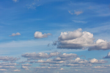Lush white clouds float in orderly lines across the bright blue sky.