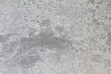 Gray-white background with a gray accent on the edges. The texture of decorative plaster.