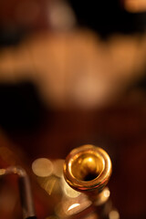 A gold plated trombone mouthpiece with a shallow depth of field