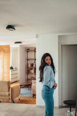 Attractive young businesswoman getting dressed for work at home