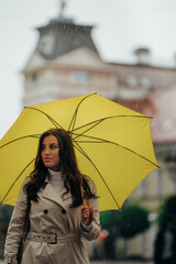 Woman holding a yellow umbrella during a heavy rain in the city