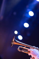 A person playing the trumpet in stage lights