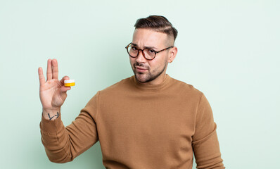 young handsome man feeling sad, upset or angry and looking to the side. contact lens