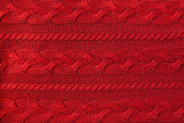 Knitted woolen background, red texture. Knitted fabric.