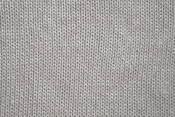 Fototapeta na wymiar background of knitted texture of fabric of pale color or knitwear closeup
