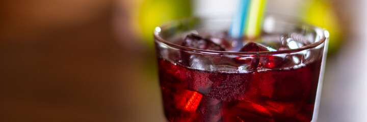 cherry red alkohol drink on wooden table closeup panorama
