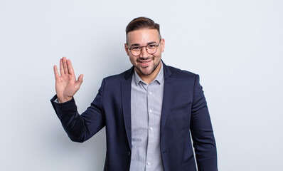 young handsome man smiling happily, waving hand, welcoming and greeting you. businessman concept © kues1