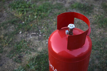 Red gas household bottle with shiny valve