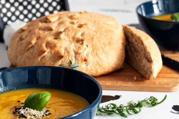 Delicious healthy autumn dinner. Pumpkin cream soup and freshly baked whole grain bread