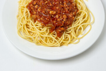 Spaghetti with meat gravy on a white plate. Traditional cooking