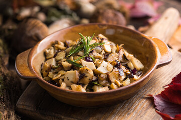 Fried forest mushrooms, boletus, onions. Rustic dish in a frying pan, vegetarian autumn food on top of view