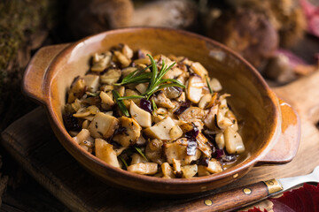 Fried forest mushrooms, boletus, onions. Rustic dish in a frying pan, vegetarian autumn food on top...