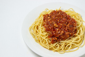 Spaghetti with meat gravy on a white plate. Traditional cooking