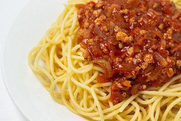 Spaghetti with meat gravy on a white plate. Traditional cooking