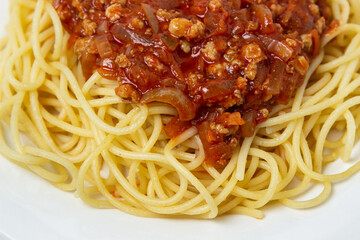 Spaghetti with meat gravy on a white plate. Traditional cooking