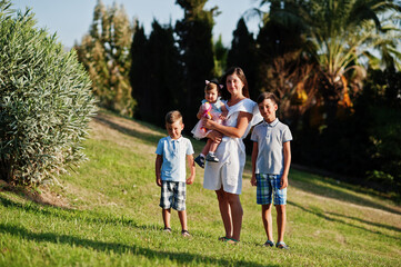 Obraz premium Mother with three kids on Turkey resort against palms.